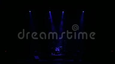 蓝光在黑暗中在一个空的舞台上闪烁着白色的光芒。